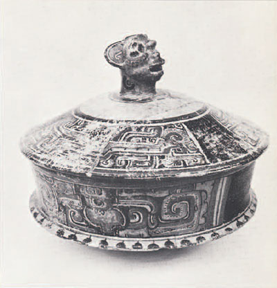 A lidded bowl with a jaguar head handle.