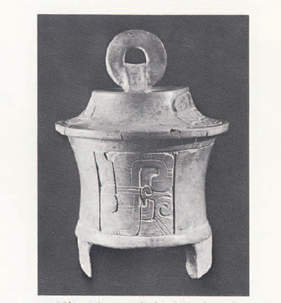 Cylinderical, lidded vessel with handle and legs.