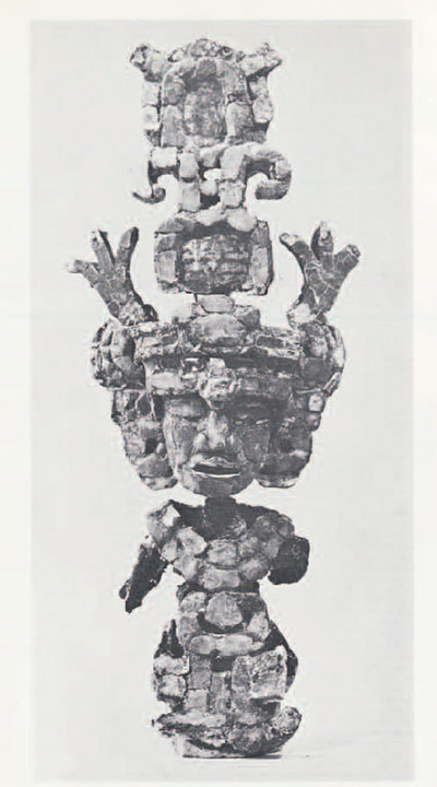 A figurine made of small pieces of jade mosaiced on a form, showing a person with an elaborate headdress.
