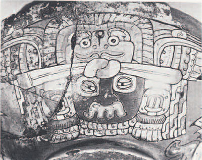 Close up of a depiction of a face and animal headdress found on a vessel.