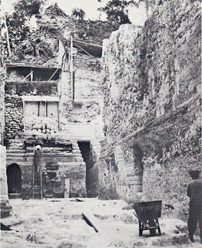 An excavated acropolis area, with tall walls and entrances to inner rooms.