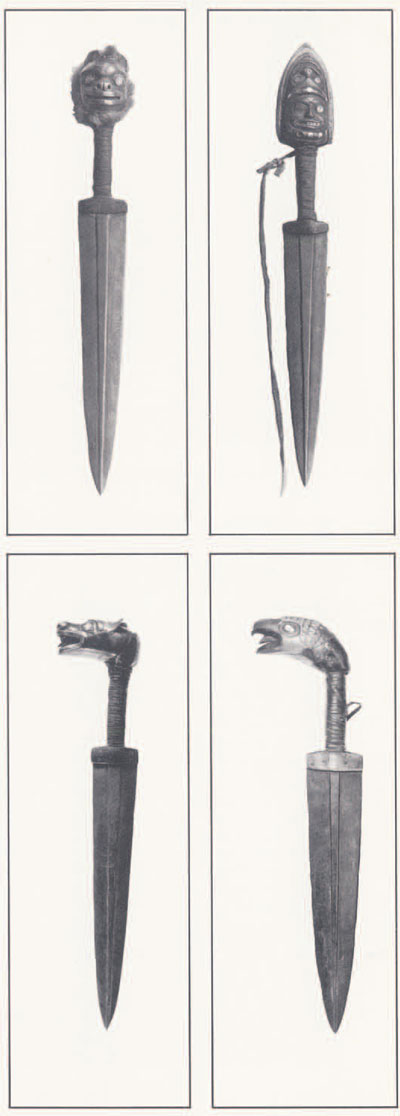 Four daggers, each with a ridge down the center of the blade. The four handles each are carved into a different animal head.