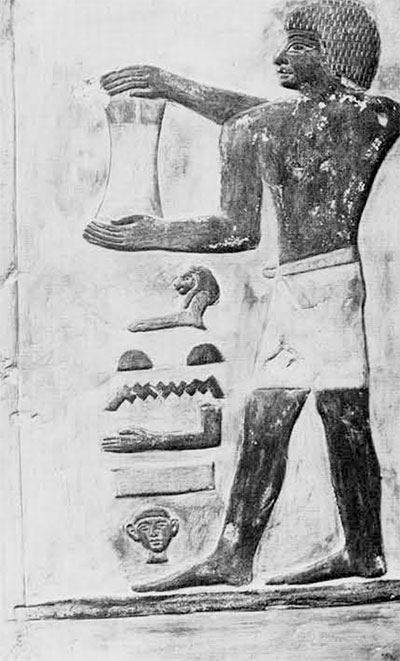 Old Kingdom offering bearer carrying urn with cedar oil. Height of figure, 24.5 cm. Goudsmit collection. 