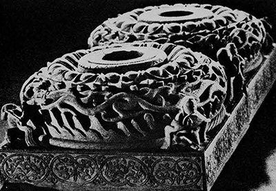 Pair of stone pillar bases from the tomb of Ssū-ma Chin-lung who died A.D. 484. This tomb, situated 13 miles southeast of Tatung, province od Shansi, was excavated in 1966. The square socle is engraved with a delicate flower motif in flat relief. In the upper section below the lotus leaves, winding dragons are worked in deep relief and four charming, free-standing figures of musicians and dancers are placed at the corners. One of them has quite a whimsical expression. The workmanship testifies to the perfection reached in the art of stone sculputure in North China and particularly in Tatung during this time. The position of the pillar bases in the tomb suggests that the wooden posts inserted into the bases. Each side, 32 cm.; height, 16.5 cm. Wên-wu 1972. No. 3.