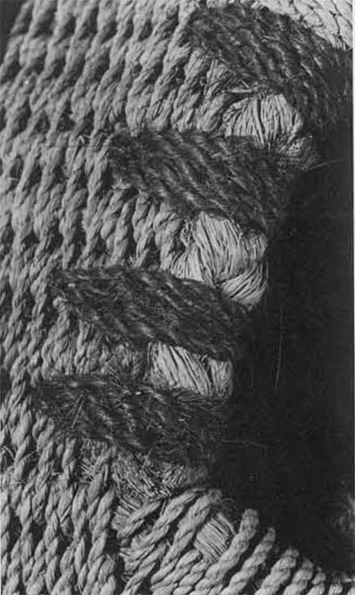 Close-up of corselet P3294A, showing the braided bundle of coconut fiber bound along the endge of an arm hole. Similar bundles of fiber are lashed together to form the body of the corselet and the high, stiff back. 