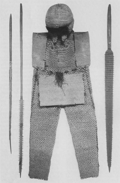 Coconut fiber overalls (P3295) and helmet (P2161), with sharks' teeth weapons (P4949 and 17768, left and P4938, right). Although they do not appear in the Anderson catalouge, the overalls are listed in the University Museum accession file as having come from R.L. Stevenson.