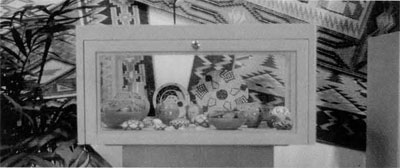 A display of Hopi pottery and baskets in a locked case.
