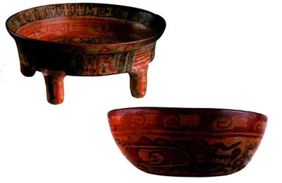 A red, four-legged, shallow dish with a slight flared lip, and a red bowl.