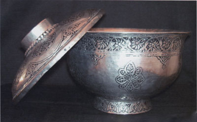A bronze and silver tureen with lid, with rosette patterns.