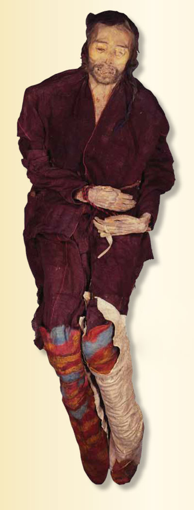 Mummified remains of a tall man in a red robe and knee high shoes.