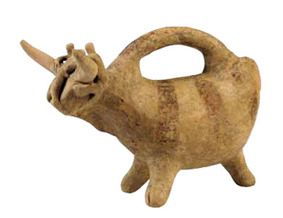 A clay pitcher in the shape of a bull, a handle rising from its back.