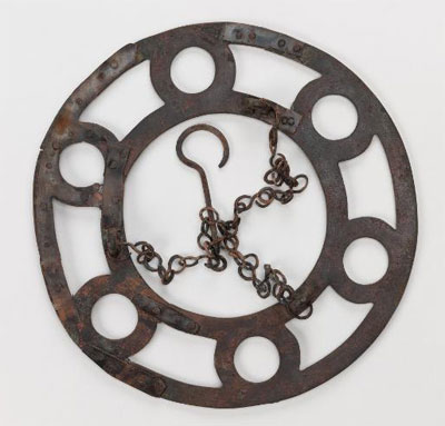 A bronze polykandelon found on the Lower North Terrace, with portions of its suspension chains surviving. Glass lamps filled with oil would have rested in the six round openings. Museum Object Number: 29-108-29