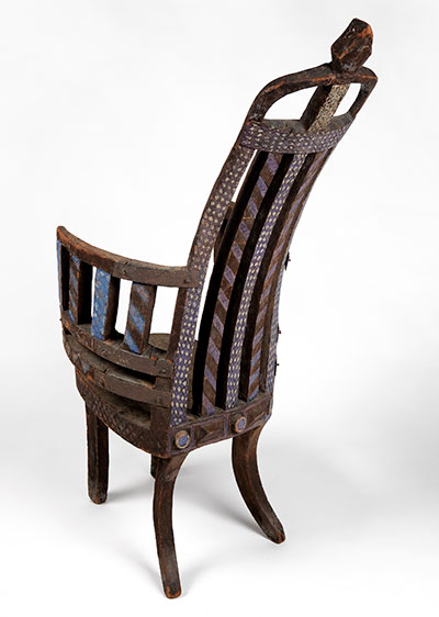 This carved European-style “prestige chair”—incised and painted, with an iron bar repair/reinforcement—was associated with King Toffa I of Porto- Novo. UPM object #2003-48-5.