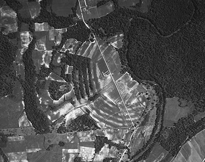 Aerial photograph taken in 1938 of Poverty Point in West Carroll Parish, Louisiana. The six concentric earthen ridges surrounding the central open space are difficult to see from the ground, but stand out clearly from the air. The outer ridge is three-quarters of a mile in diameter and the site overall covers more than 500 acres. Image courtesy of P2 Energy Solutions/Tobin Aerial Archive.