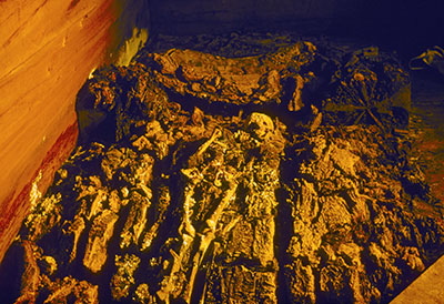View of tomb from the entrance, remains laying in a coffin.