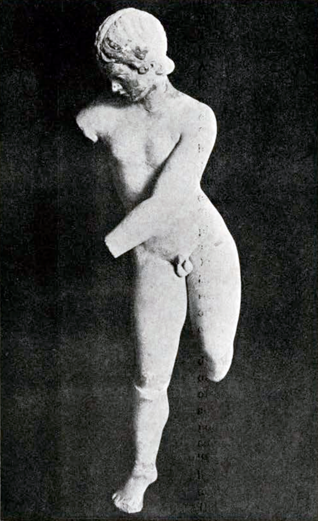 A marble statue of naked Eros, right arm missing and left hand missing, in a stance which suggests him bending his bow.