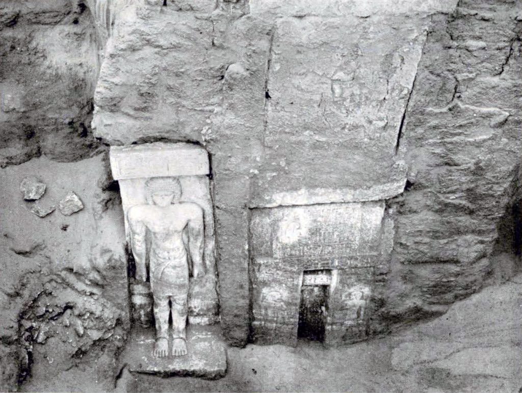A figure and stela carved into the walls of a tomb