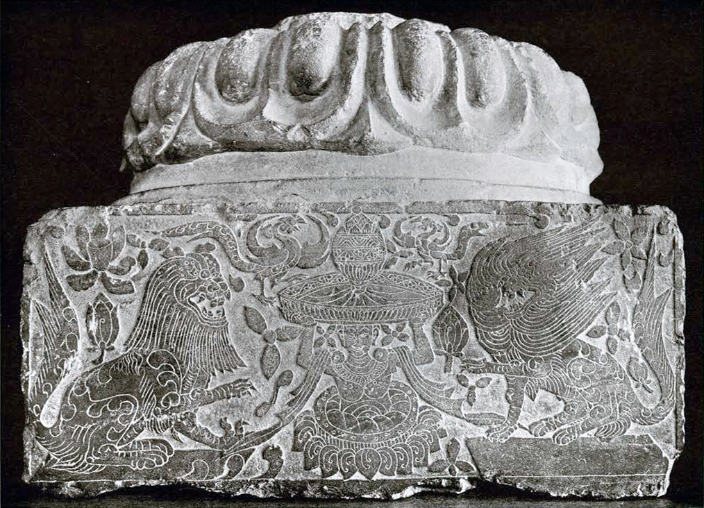 Low relief carving on one side of a four sided limestone pedestal showing a humanoid figure holding an incense burner flanked by two lions