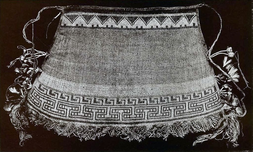 A beaded apron with a triangular pattern along the top and two bands of zig zagging patterns along the bottom