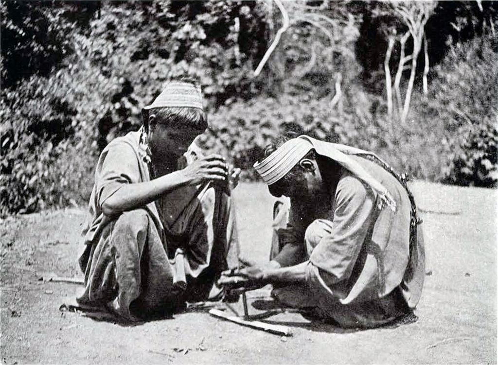 Two Macoa making fire with stick drills