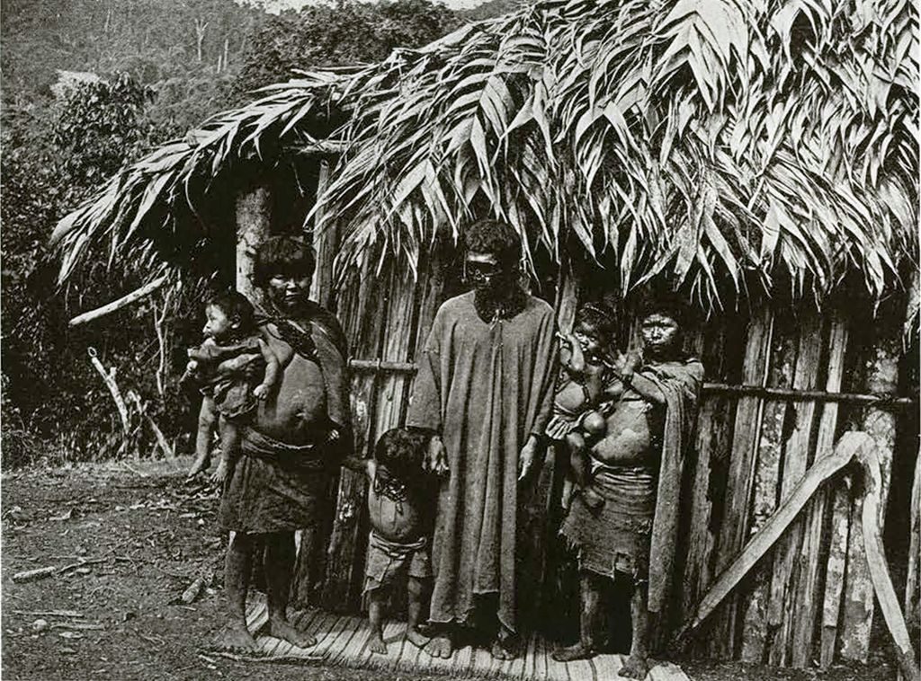 Macoa chief and his family, standing in front of a hut