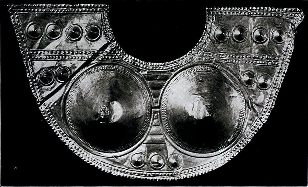 A half circle gold breastplate with several small bosses