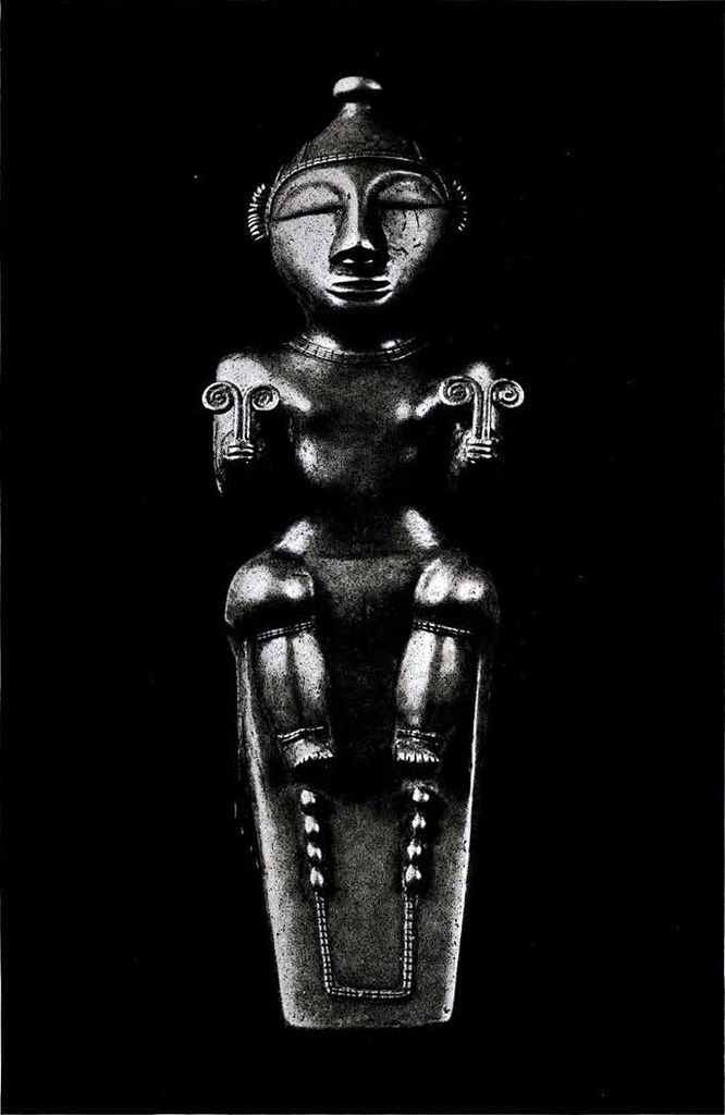 A gold flask in the shape a seated female