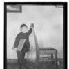 Sa-lan-x. Male child standing, holding onto a chair, with book under arm. Haines, Alaska. 1925