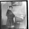 Yak-xudedu-sak. Young girl with ribbons in her hair, hands on arm of rocking chair. Haines. Alaska. 1916