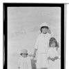 Yak-xu-det-sak, Na. Ls. Three children standing. Two holding hands, one holding American flag. July 4, 1918.