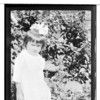 Txut-ki. Young female standing in undergrowth. Near modern house. June 1918. Haines, Alaska.