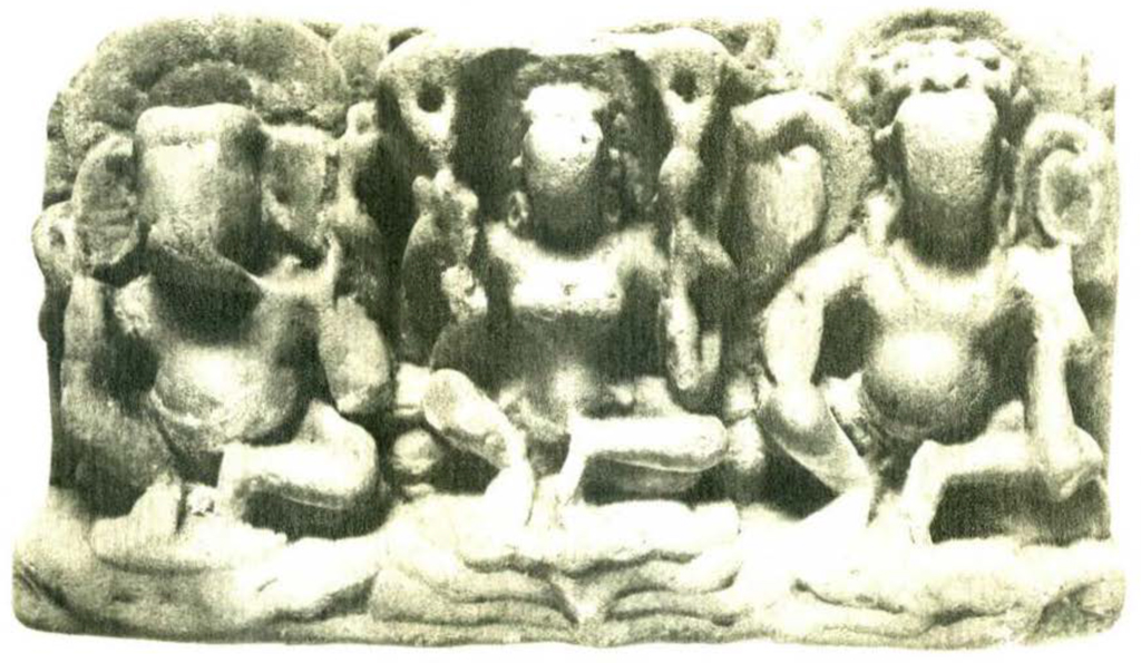 A sandstone relief showing three seated figures, wornd down greatly