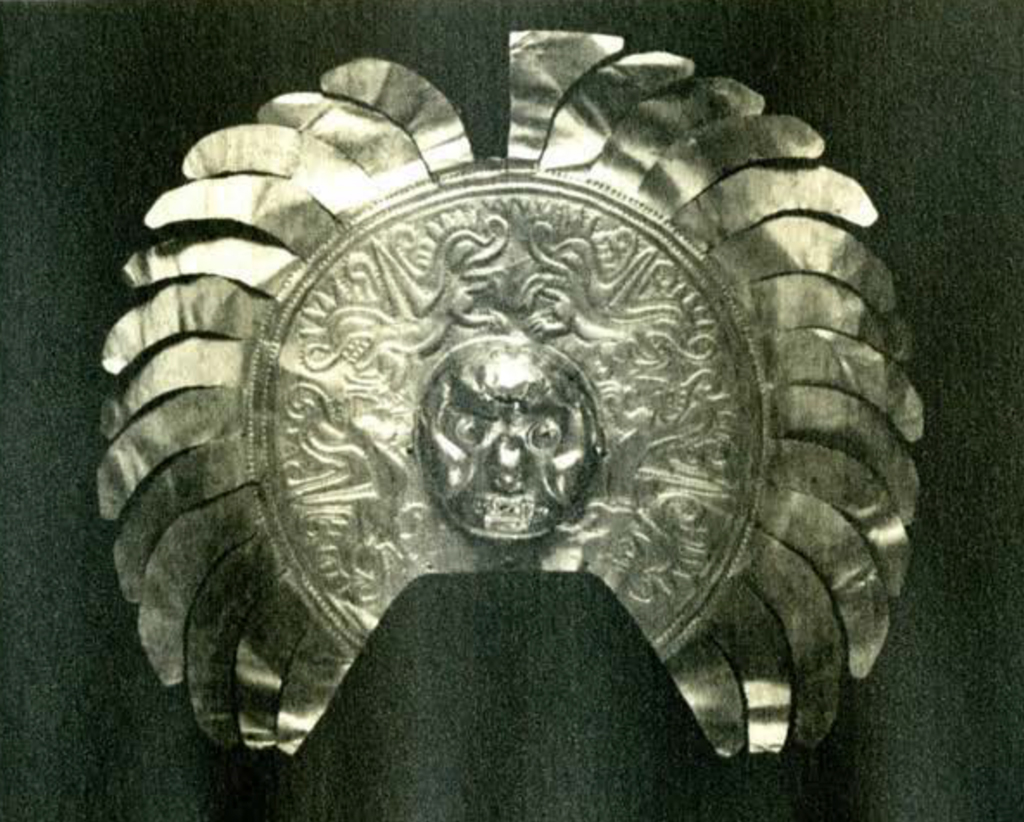 Gold breast plate depicting a human head and several alligators