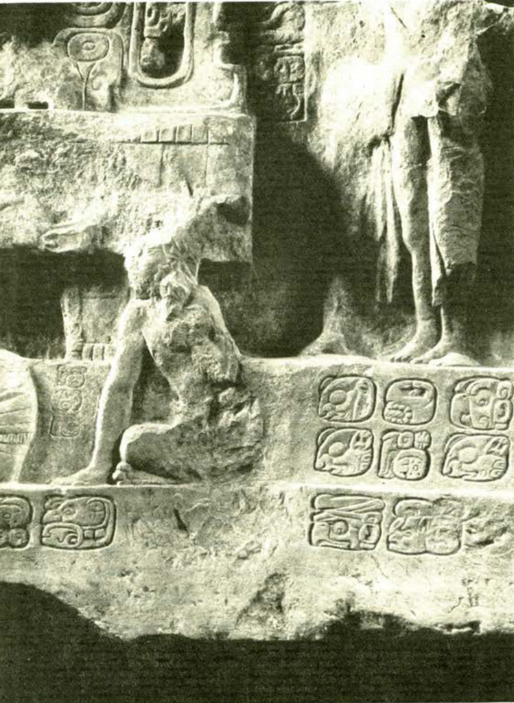 Close up of a stone lintel showing a seated figure with hieroglyphs