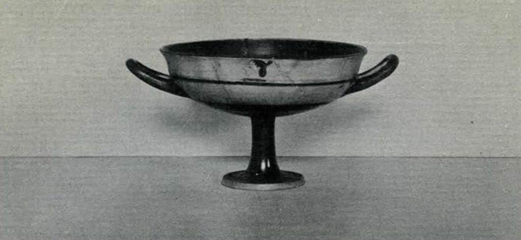 A shallow cup with a tall foot and two handles
