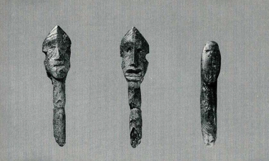 Three carved ivory figurines with crude faces
