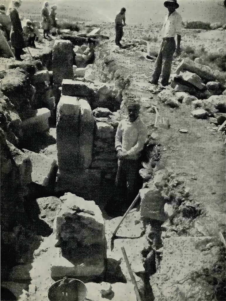 Men excavating a trench full of stone walls