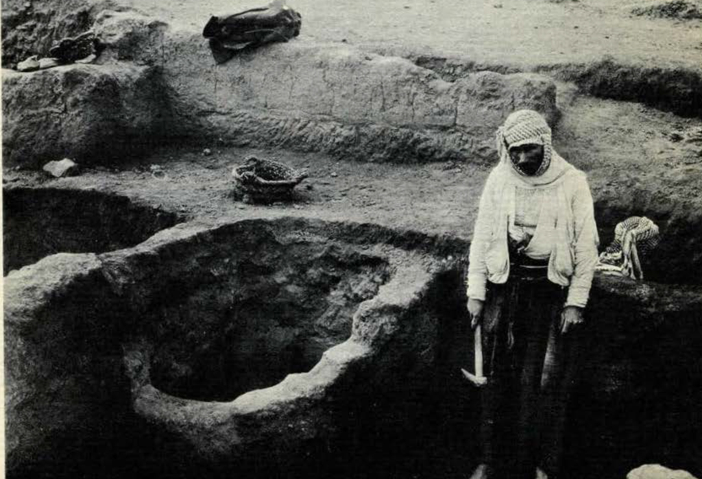 A man holding a pick axe next to an excavated storage area