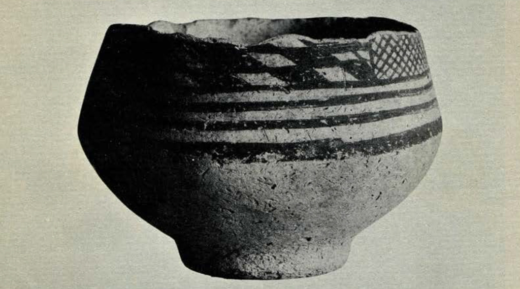 A footed bowl with painted stripes, checkerboard pattern, and cross hatching