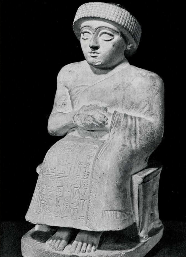 Complete Gudea statue, a seated man with his hands folded in a one shoulder garment and turban