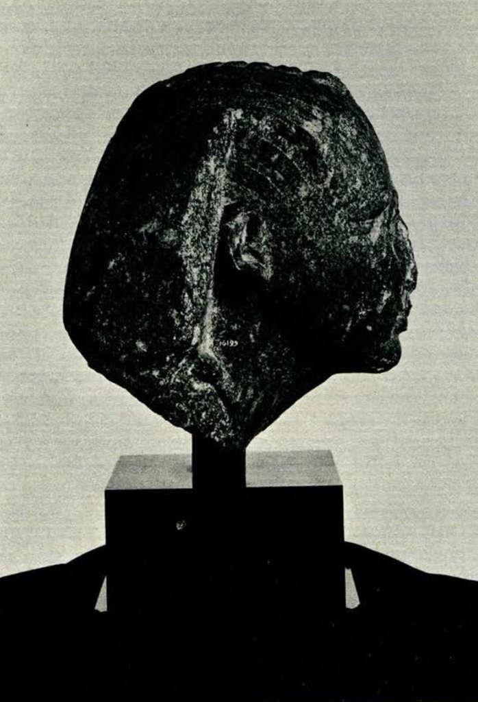 Head from a statue of a Egyptian king wearing a headdress with pieces missing, profile