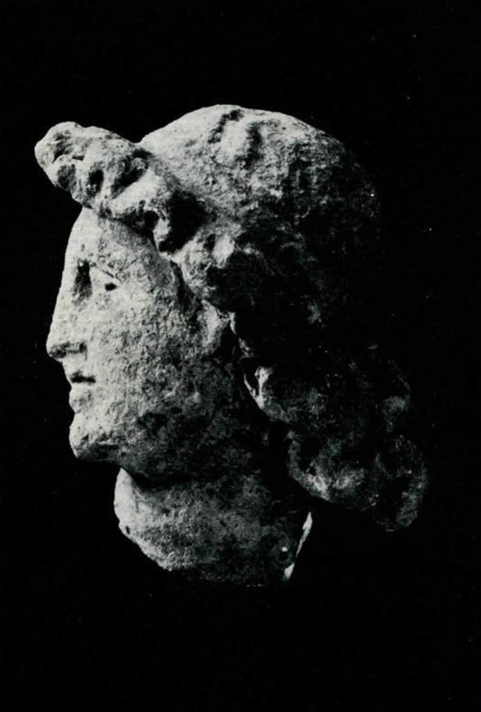 Terra cotta head of Apollo with halo of curly hair, profile view