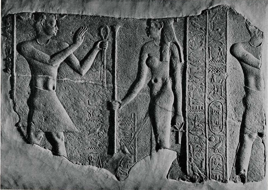 Bas relief of a man presenting fabric to Isis, she holds a staff and an ankh