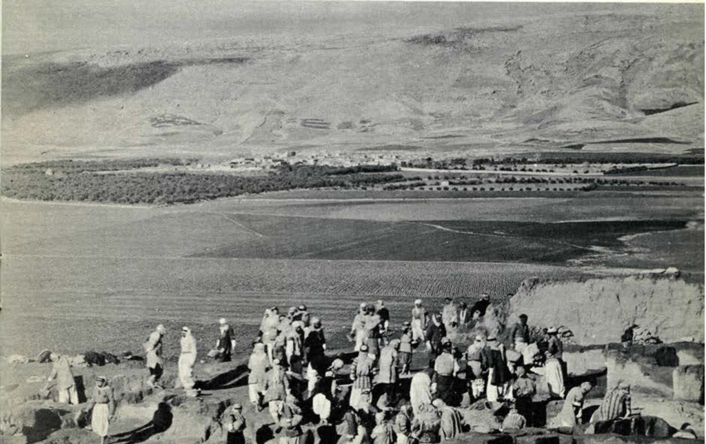 View of a village from the top of the mound of Tepe Gawra, people gathered in the foreground