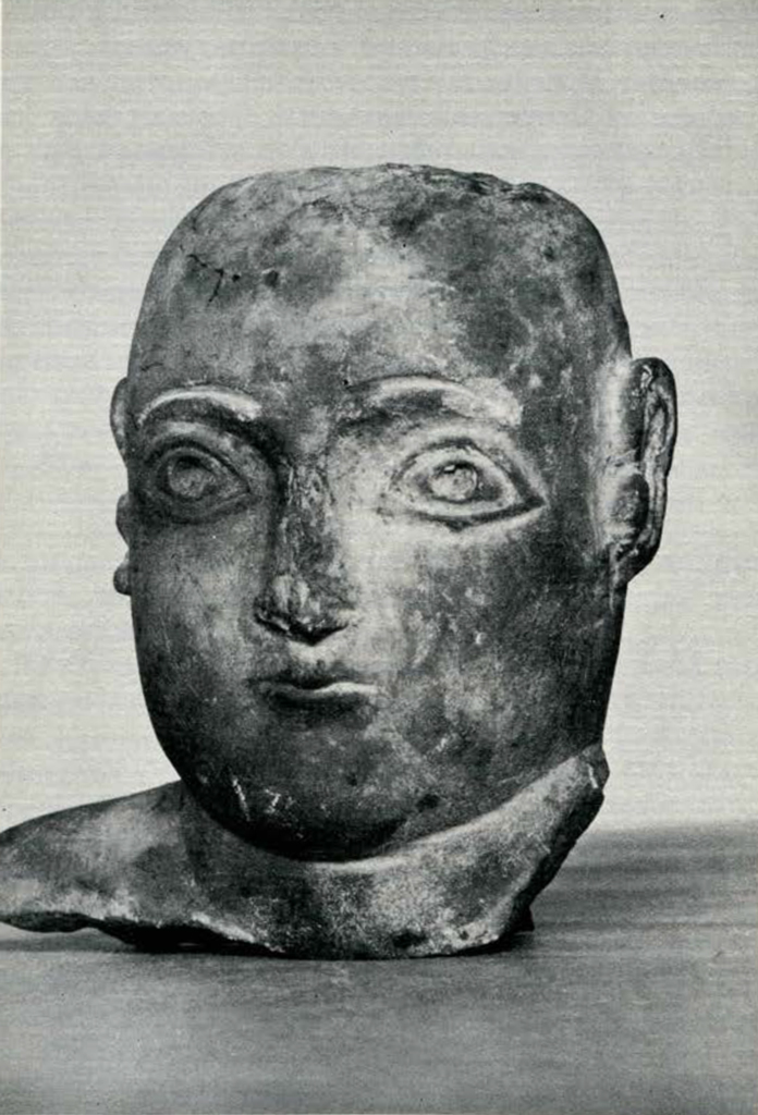 Head and part of a shoulder of a statuette with incised eyes and eyebrows