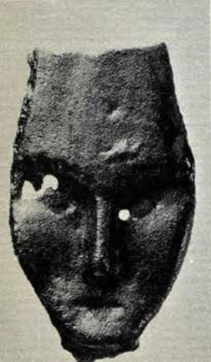 Small bronze plaque in the shape of a long narrow human face