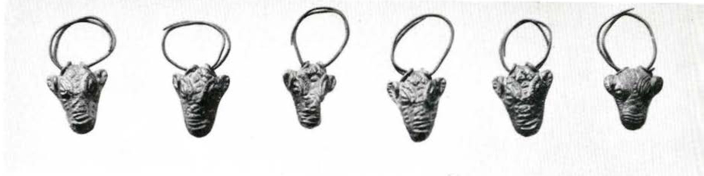 Six small figures of animal heads on wire coils