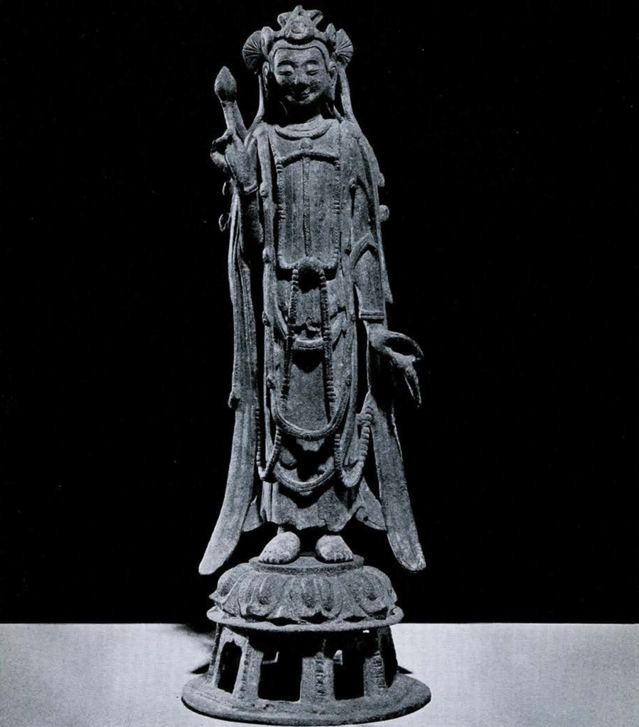 Bronze figure of Dashizhi, a bodhisattva belonging to the retinue of the Amitabha Buddha, standing on a low lotus pedestal with right hand raised holding lotus bud, left hand hanging and holding an object which may be a leaf or the precious pearl, sacred pearl in center of headdress, and Elaborate scarves and drapery.