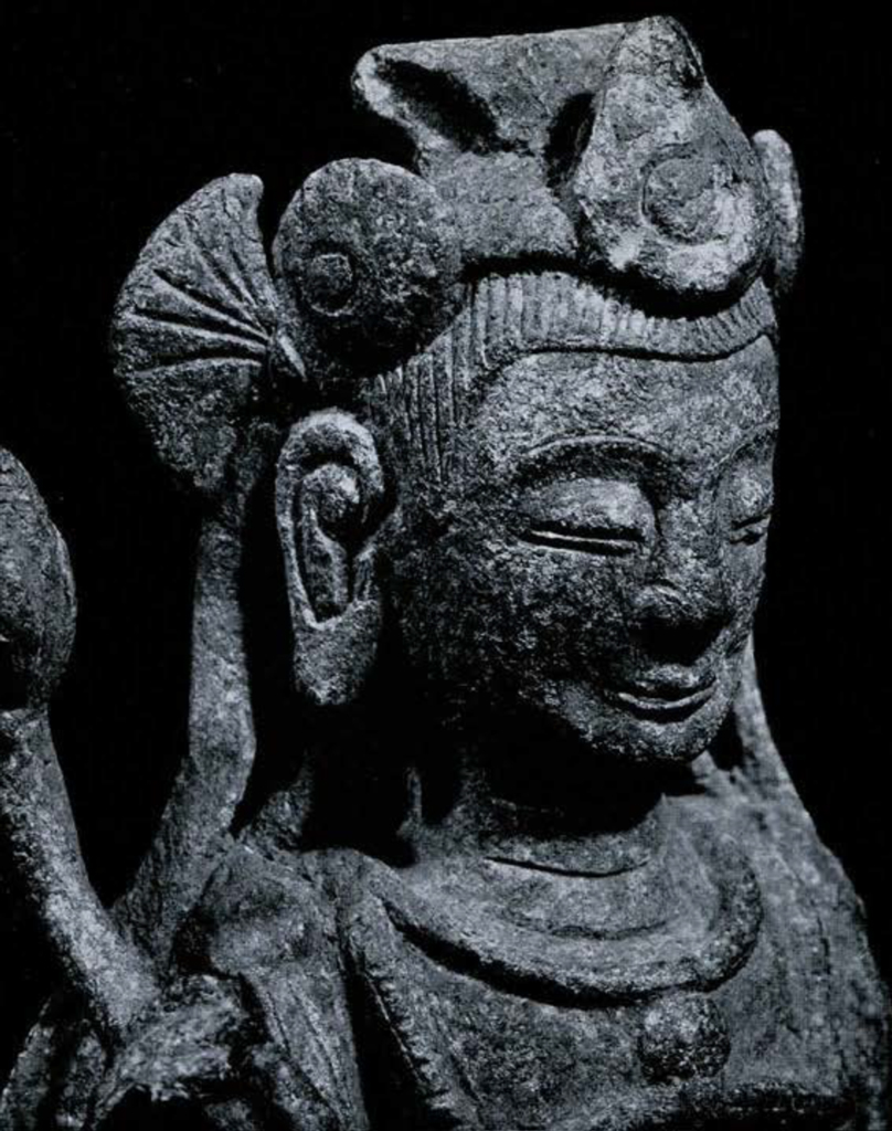 Close shoulders up view of a bodhisattva showing ornate headdress and long earlobes