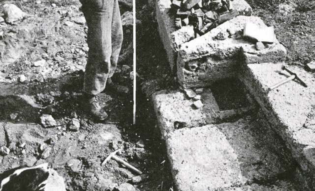 A metre stick in the ground in an excavated area of a temple